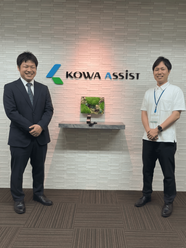 興和アシスト株式会社様と株式会社アップロード担当者の握手写真